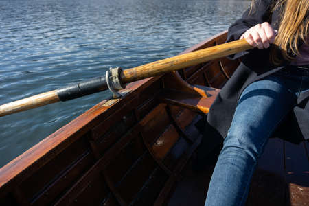 Young woman using paddle on a wooden boat - Lake Bled Slovenia rowing on wooden boatsの写真素材