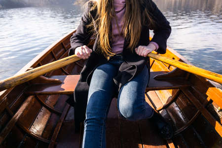 Young woman using paddle on a wooden boat - Lake Bled Slovenia rowing on wooden boatsの写真素材