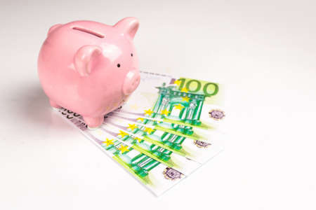 Piggy bank isolated on white background with EU euro billsの写真素材