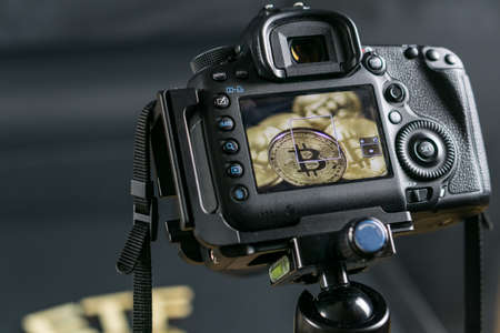 DSLR camera taking a macro photo of Bitcoin coins. Bitcoin under eye of goverment conceptの写真素材