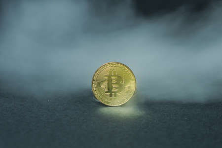 Golden bitcoins with smoke on black background. Business concept. Internet security and protection concept.の写真素材