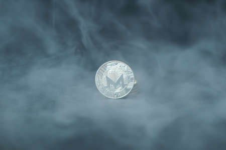 Silver Monero with smoke on black background. Business concept. Internet security and protection...