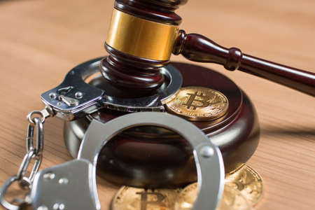 Bitcoin regulation. BTC cryptocurrency coin and judge gavel on a desk. Banned currency or law enforcement concept.の写真素材