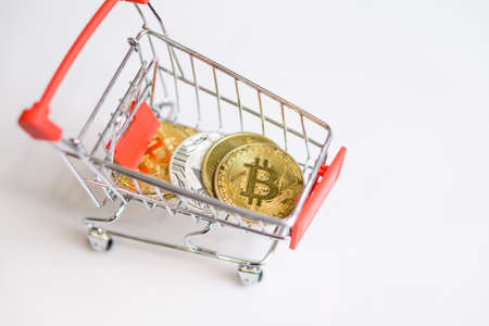 Shopping trolley cart with Coins bitcoin, buying goods for crypto currency.の写真素材