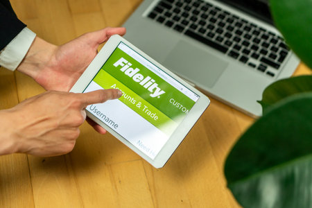 Ljubljana, Slovenia 29.4.2019: businessman holding computer tablet with opened Fidelity website on a...