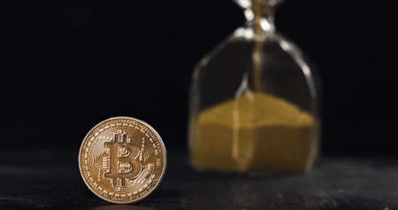 Bitcoin hodl for years and get rich concept, time is running out. Bitcoin coin next to hourglass