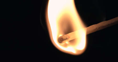 Firing up matches. Ignition lose-up detail of on matchbox and showing burning flameの写真素材