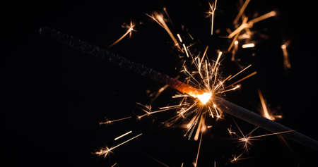 Firework festive sparkler burning on black background