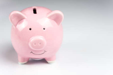 Pink piggy bank on white background with reflectionの写真素材