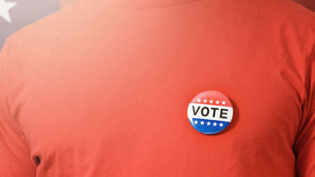 Man puting on Vote button for Presidential election 2020 in America.