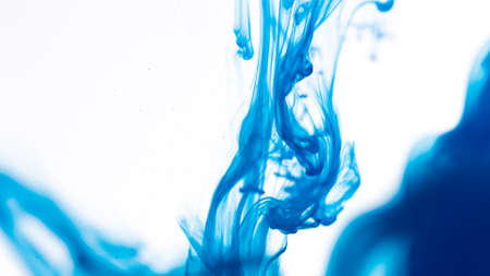 Cloud of blue color ink in water isolated on white. Abstract design and texture.の写真素材