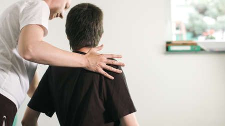 Physiotherapist exercising with disabled person on a therapy table.