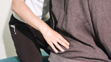 Physiotherapist exercising with disabled person on a therapy table.の写真素材