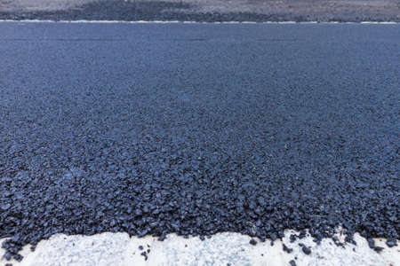 Fresh black asphalt on new street road. Construction at work.