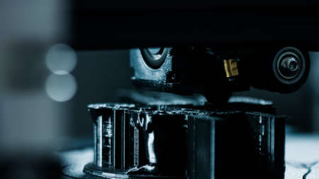 3D plastic printer during work in a factory three dimensional printing. Close-up detail.
