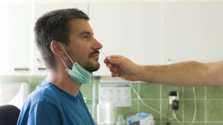 Man testing with swab for coronavirus in laboratory
