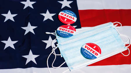 I voted today buttons on face mask with Usa flag. Coronavirus and presidential elections concept.の写真素材