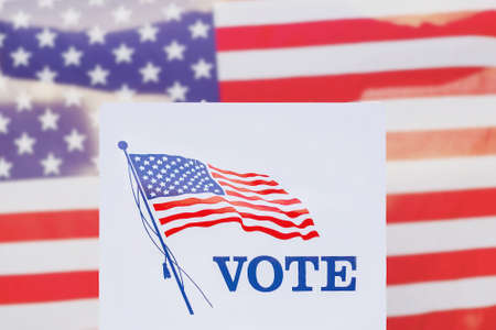Ballot box with Vote sign against american flag.