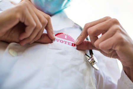 Doctor with I voted today badge on his uniform.