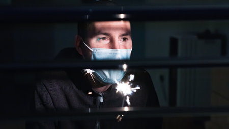 Man in Quarantine for new year Looking out the Window. Staying Home at Lockdown.の写真素材