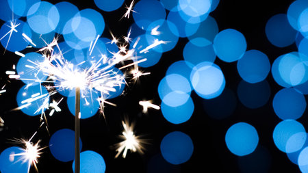 Holiday sparkler against blue lights background. Festive decoration for christmas new year.の写真素材