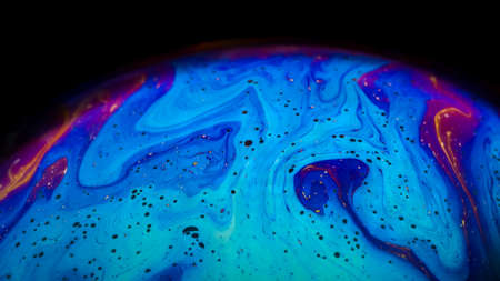 Fluid soap bubble looking like planets. Psychedelic colorful abstract art with urreal patterns of color in motion.の写真素材