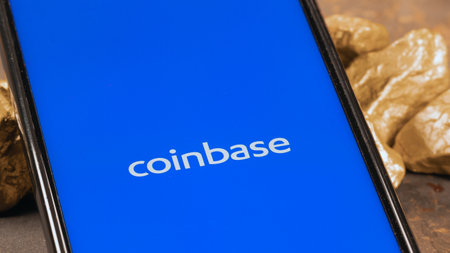 Coinbase crypto exchange logo on screen with gold. Ljubljana, Slovenia - April 12 2021