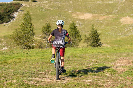 Girl child riding mountain bike at sunset. Beautiful golden summer light.の写真素材