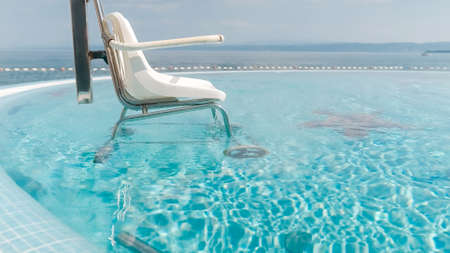 Pool wheelchair lift for transfer into water.
