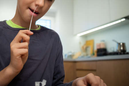 Child self testing for virus at home before going to school.