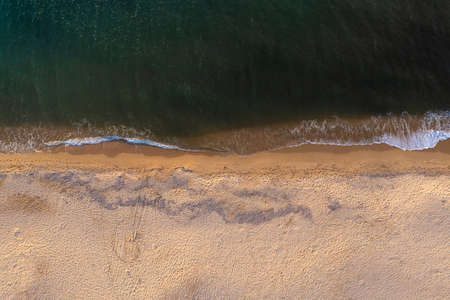 Aerial top down view of beautiful white sand beach bathed by clear turquoise seawater.の写真素材
