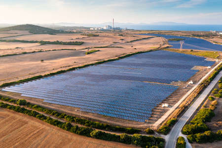 Drone close-up shot of solar panels field, photovoltaic power station illuminated by sunbeams at...