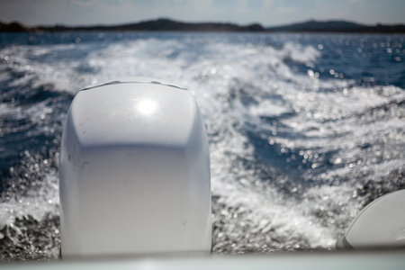 Close-up shot of motorboat engine during the drive on the beautiful blue seawater. Foam trail, boats...