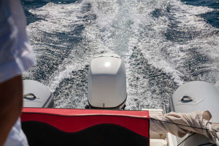 Close-up shot of motorboat engine during the drive on the beautiful blue seawater. Foam trail, boats wake, in the seawater.の写真素材