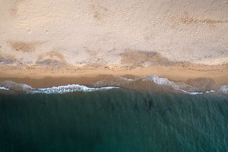 Aerial top down view of beautiful white sand beach bathed by clear turquoise seawater.の写真素材