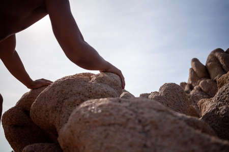 Man climbing on a sand rock mountain in natureの写真素材