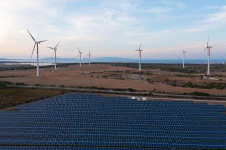 Solar panels and wind turbines producing green energy for clean environment.