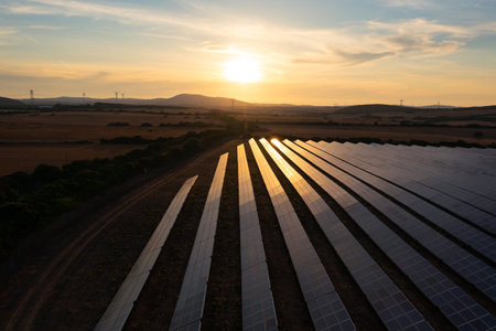 Solar panel farm under sunset sky reflecting light.の写真素材