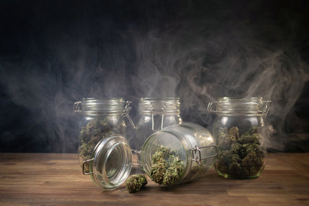 CBD hemp weed buds stored in a glass jar shrouded with a smoke cloud. Medical cannabis.の写真素材