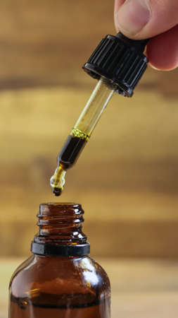 CBD cannabis oil dripping from pipette. Vertical imageの写真素材