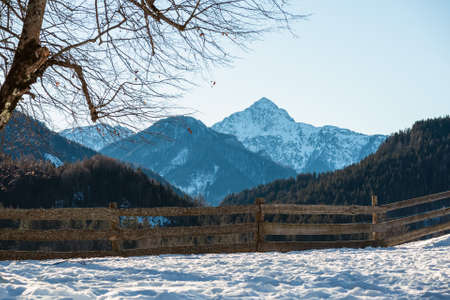 Ski resort in Alpine foothill, ski trails with a wooden fence during the winter season. Jezersko, Sloveniaの写真素材