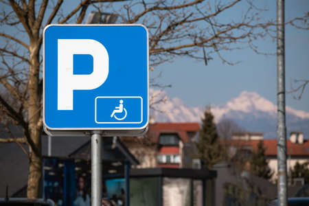 Parking spot for persons with disability with wheelchair sign.