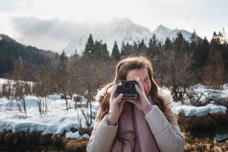 Young woman photographing with retro instant film camera for vintage style picture.の写真素材