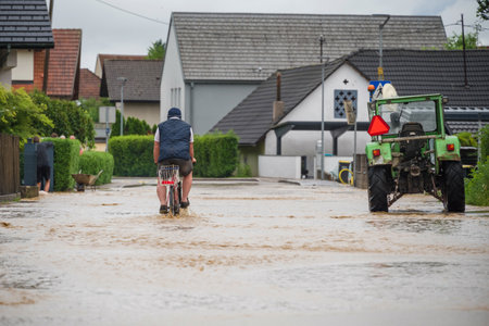 People in floods at city streets after heavy rain. Severe weather disaster.の写真素材