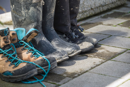 Muddy boots after floods in the city streets after heavy rain. Severe weather disaster.の写真素材