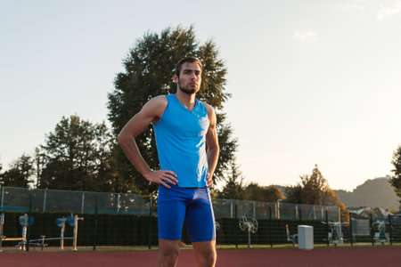 Young man training for run race start on a stadium track outsideの写真素材