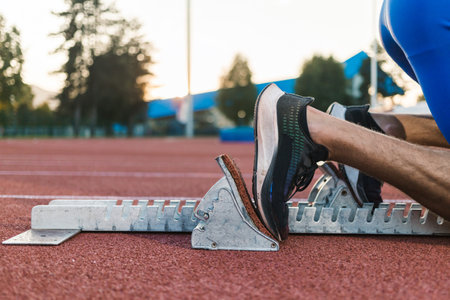 Male sprinter feet, in black sneakers, pushing off from the starting block, and start a race, close up shot.の写真素材