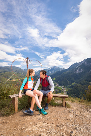 Two happy hiker couple reaching a goal, conquering a hill top enjoying in natureの写真素材
