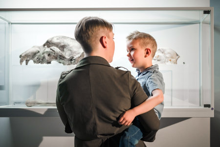 Mother and her little son enjoying watching an exhibition in a natural history museum. Children and...