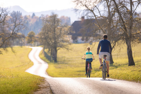 Young couple enjoying pleasant cycling in beautiful countryside during fall weekend trip. Leisure and outdoor activity concept.の写真素材